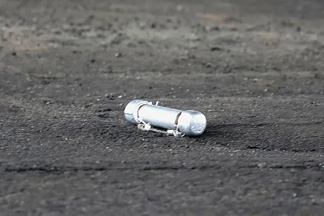 A suspicious object is seen on the ground where a suspect was arrested