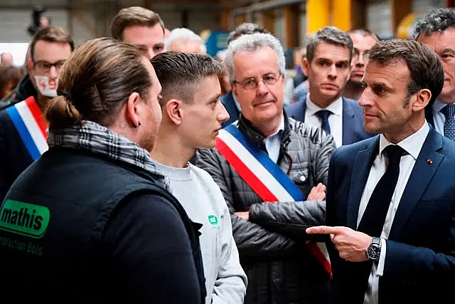 French President Emmanuel Macron, right, talks to employees during a visit to Mathis, a company specialising in large wooden buildings, in Muttersholtz, eastern France 