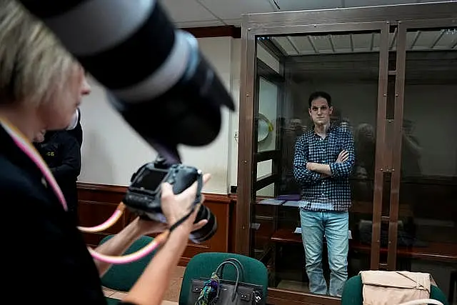 Wall Street Journal reporter Evan Gershkovich stands in a glass cage in a courtroom at the Moscow City Court