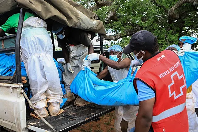 Police and local residents load exhumed bodies into the back of a truck