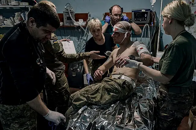 Military medics give first aid to a wounded soldier at a medical stabilisation point near Bakhmut, Donetsk region, Ukraine