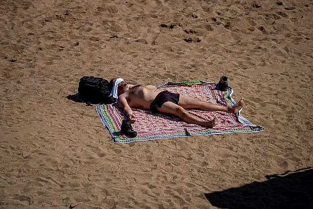 A man sunbathes on the beach in Barcelona