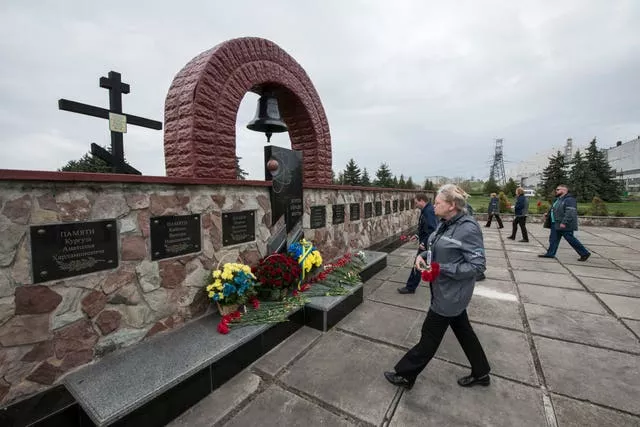 Chernobyl’s nuclear power plant workers lay flowers at a monument to the victims of the tragedy 