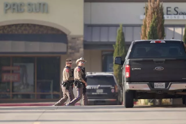 Law enforcement officers patrol a shopping centre after a shooting in Allen, Dallas, Texas