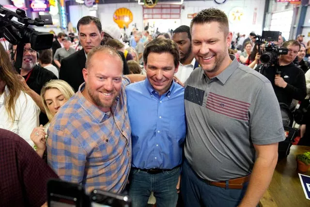 Florida governor Ron DeSantis poses for a photo with audience members in Sioux Centre, Iowa