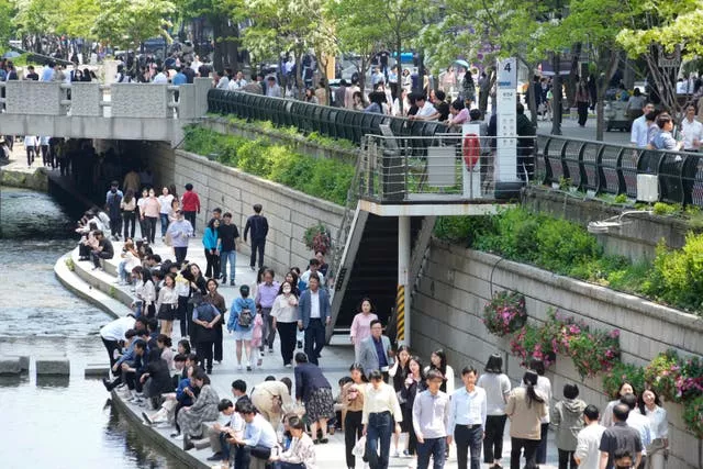 People walk along the public area of the Cheonggye Stream in Seoul