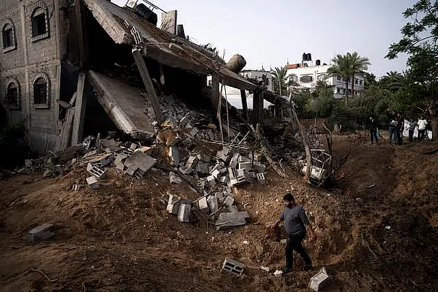 Palestinians inspect the rubble of a house after it was struck by an Israeli air strike in Deir al-Balah, central Gaza Strip 