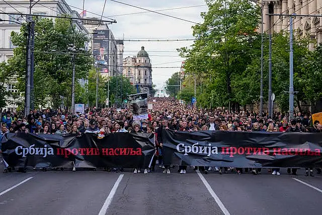 People hold banners with writing reading 'Serbia Against Violence' during a march against violence in Belgrade, Serbia