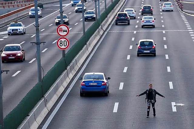 A man attempts to block a motorway during a rally against violence in Belgrade, Serbia