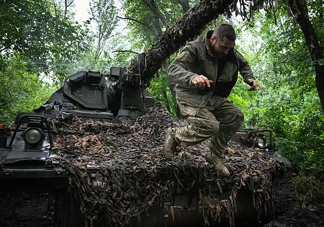 A Ukrainian soldier jumping off the German self-propelled Panzerhaubitze 2000 artillery at his position at the frontline near Bakhmut, Donetsk region