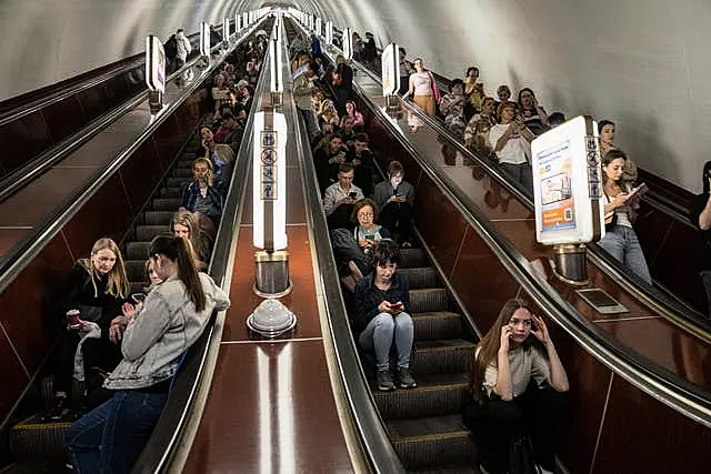 People take cover at metro station during a Russian rocket attack in Kyiv