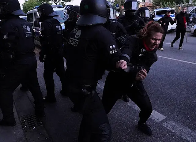 Police officers scuffle with a demonstrator after a demonstration in Hamburg, Germany