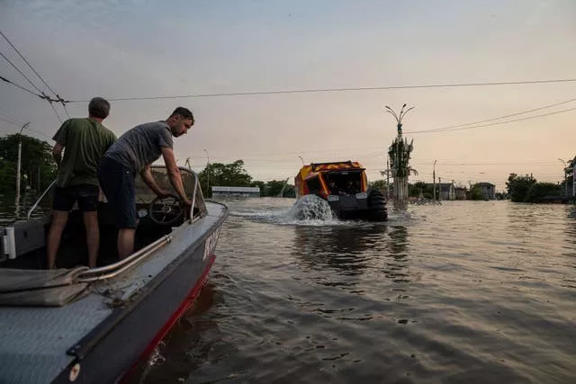 Rescue workers evacuate people by a swamp walker vehicle in a flooded neighbourhood of Kherson, Ukraine,