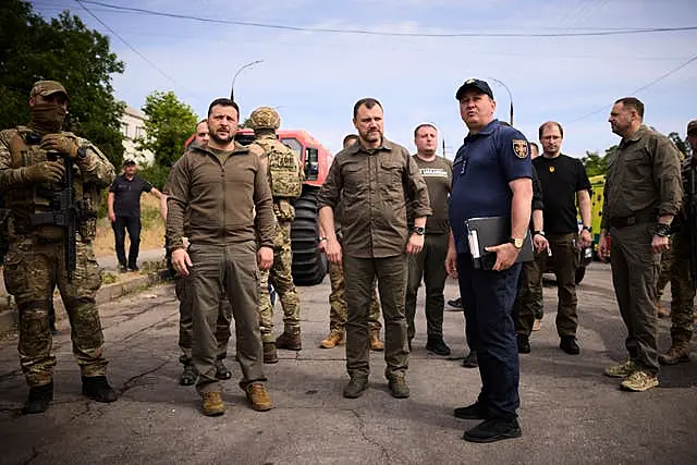 Ukrainian President Volodymyr Zelensky, left, visits the flood-hit areas in Kherson