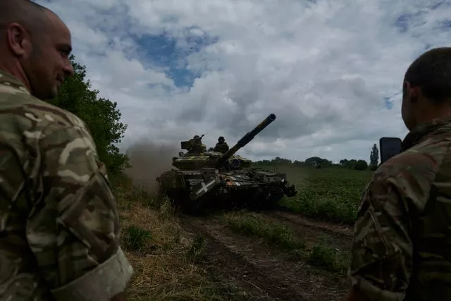 Ukrainian soldiers on a tank ride along the road towards their positions near Bakhmut