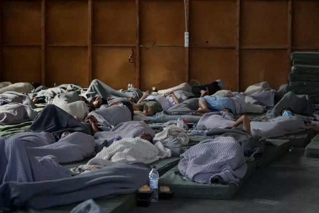 Survivors of a shipwreck sleep at a warehouse at the port in Kalamata town, about 150 miles southwest of Athens 