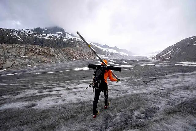 A glaciologist walks to the Rhone Glacier near Goms 