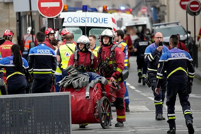 Police officers and rescue workers work at the scene in Paris