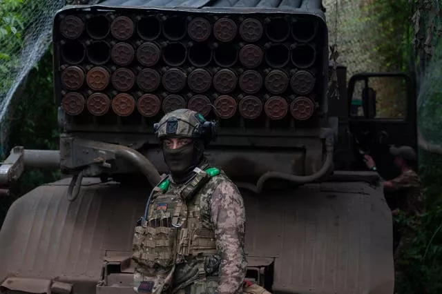 A Ukrainian soldier stands next to an MSLR BM-21 'Grad' at the front line near Bakhmut in the Donetsk region, Ukraine 