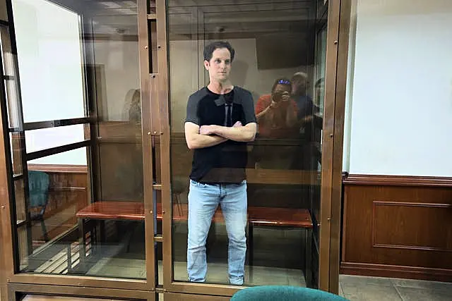 Wall Street Journal reporter Evan Gershkovich stands in a glass cage in a courtroom at the Moscow City Court