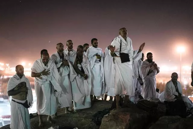 Muslim pilgrims pray on the rocky hill known as the Mountain of Mercy, on the Plain of Arafat