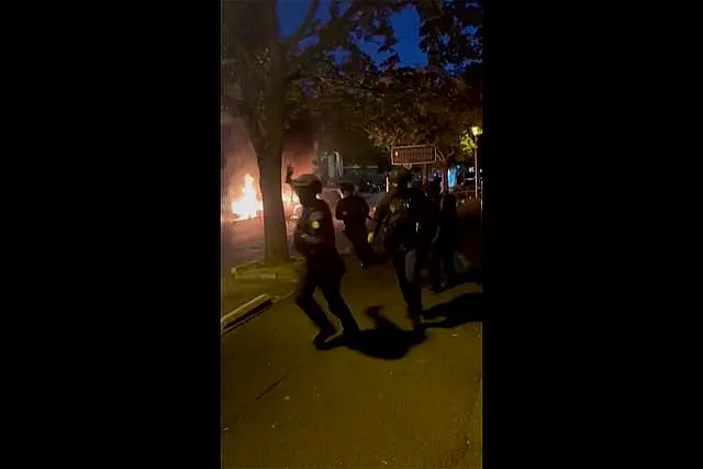 Police officers try to control people on a street in Nanterre, France