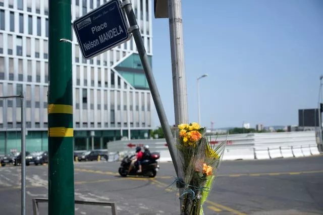 Flowers are attached to a pole where a young man was killed by a police office in Nanterre