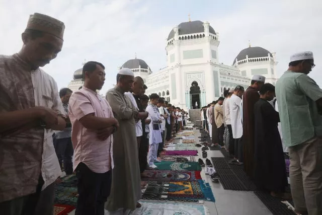 Muslims perform a morning prayer marking Eid in front of Al Mashun Great Mosque in Medan, Indonesia