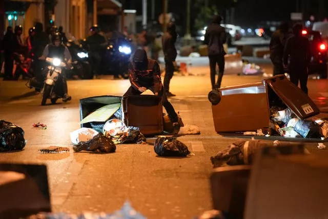 Protesters block a street with bins in Colombes near Paris