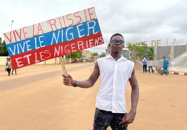 A supporter of Niger’s ruling junta holds a placard in the colors of the Russian flag reading “Long Live Russia, Long Live Niger and Nigeriens” at the start of a protest called to fight for the country’s freedom and push back against foreign interference in Niamey, Niger