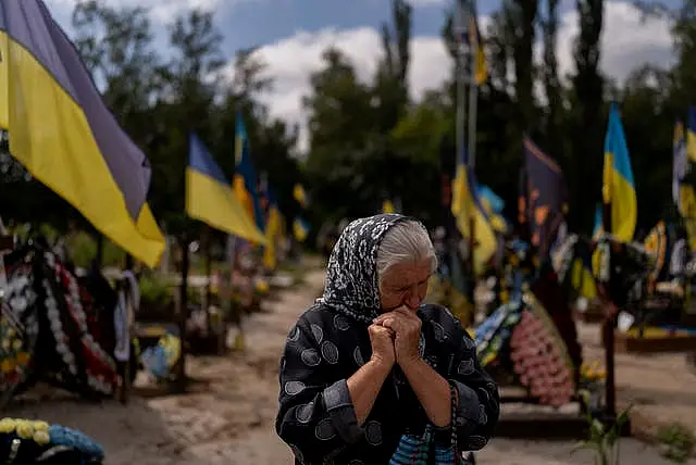 Svitlana Sushko, 62, sobs while visiting the grave of her youngest son, a Ukrainian soldier who was killed last year in the war against Russia, in Kyiv, Ukraine