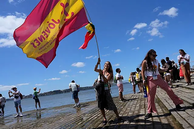 Pilgrim in the water waves a Spanish flag