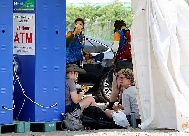 Attendees of the World Scout Jamboree rest under the shade at the scout camping site in Buan, South Korea 