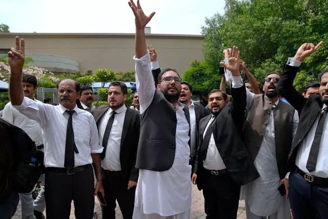 Lawyers and supporters of Pakistan’s former prime minister Imran Khan chant slogans against the court decision at his residence, in Lahore, Pakistan