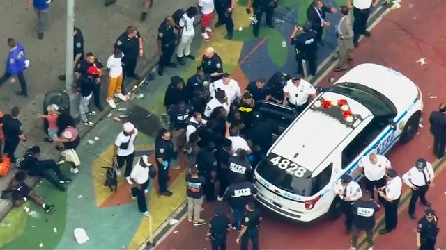 Crowd of people around a police car