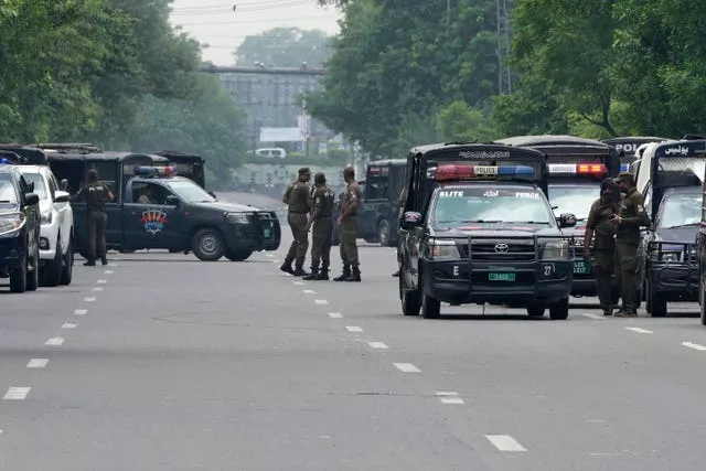 Police officers prepare to take positions outside the residence of Pakistan’s former prime minister Imran Khan, in Lahore, Pakistan