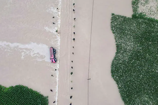 A truck turned on its side is seen as floodwaters flow across roads and fields in Kaiyuan Town of Shulan in north-eastern China’s Jilin Province