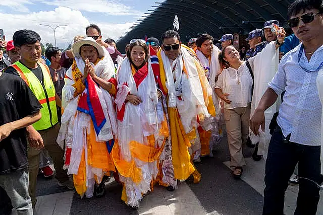 Norwegian woman mountain climber Kristin Harila, centre, and her Nepali Sherpa guide Tenjen Sherpa, left, who on Thursday set a new record by scaling the world’s 14 highest peaks in 92 days arrive at the airport in Kathmandu, Nepal