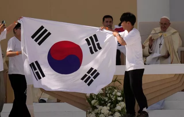 South Korean pilgrims hold their national flag 