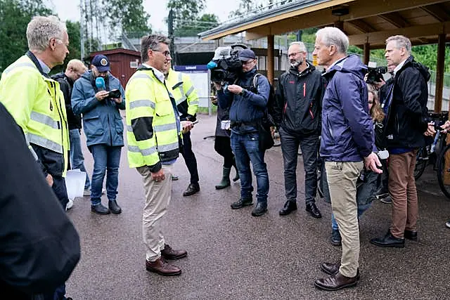 Norway’s Prime Minister and transport minister Jonas Gahr Store and Jon-Ivar Nygard talk to the media at the site damaged by flood