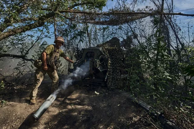 A Ukrainian serviceman fires a cannon towards Russian positions at the front line in Donetsk