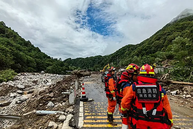 Rescue workers gather at the aftermath of a mudslide in Weiziping village of Luanzhen township