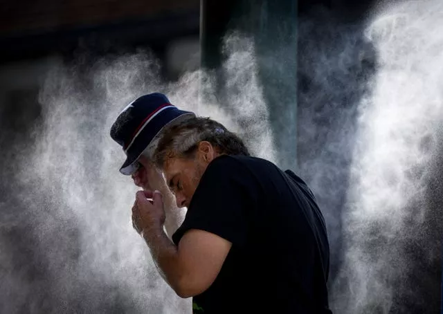 A man cools off at a temporary misting station in Vancouver