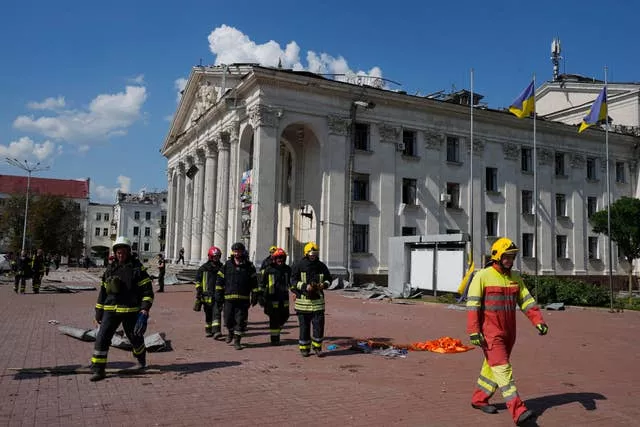 Bombeiros perto de edifícios danificados em Chernihiv, Ucrânia