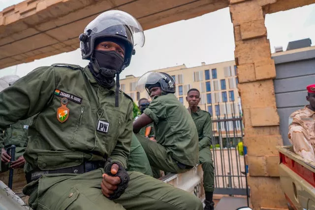 Nigerien police officers sit outside the customs offices in Niamey