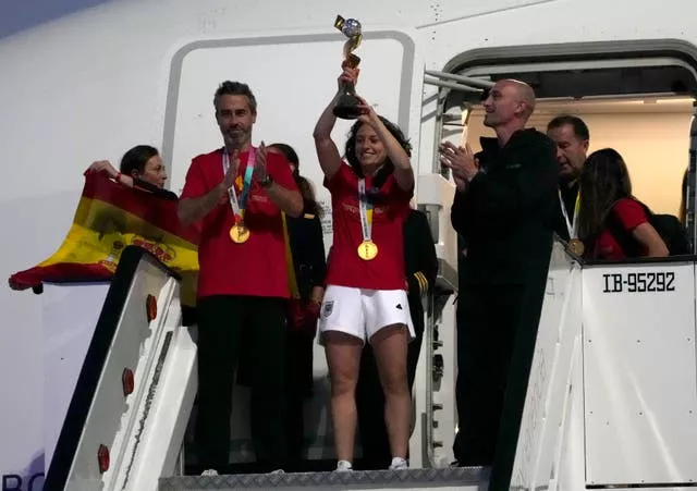 Spain’s Ivana Andres lifts the trophy with other members of the squad on their arrival at Barajas international airport in Madrid