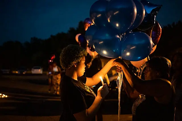 Nadine Young, right, the grandmother of Ta’Kiya Young, gathers with family and friends during a candlelight vigil