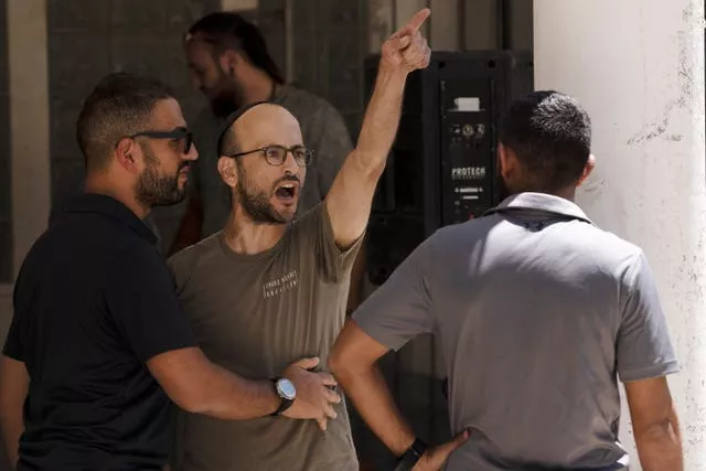 An Israeli settler heckles other Israelis protesting near Itamar Ben Gvir's home