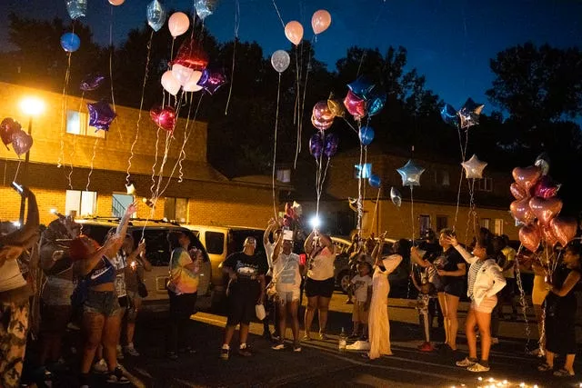 Family and friends release balloons at a private vigil