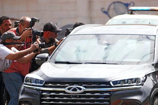 Fotojornalistas cobrem a chegada do veículo que transportava o ex-presidente Jair Bolsonaro à sede da Polícia Federal em Brasília, Brasil